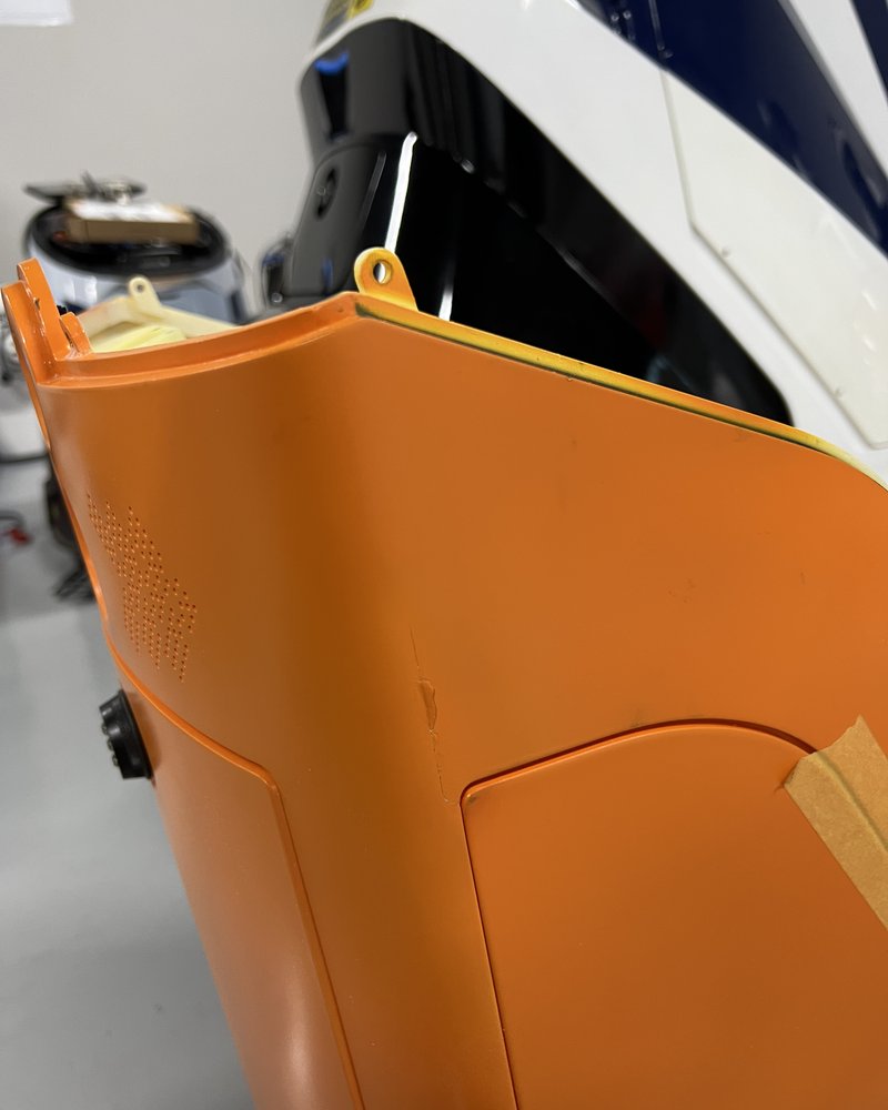 An orange service-robot body panel mid-repair in the workshop