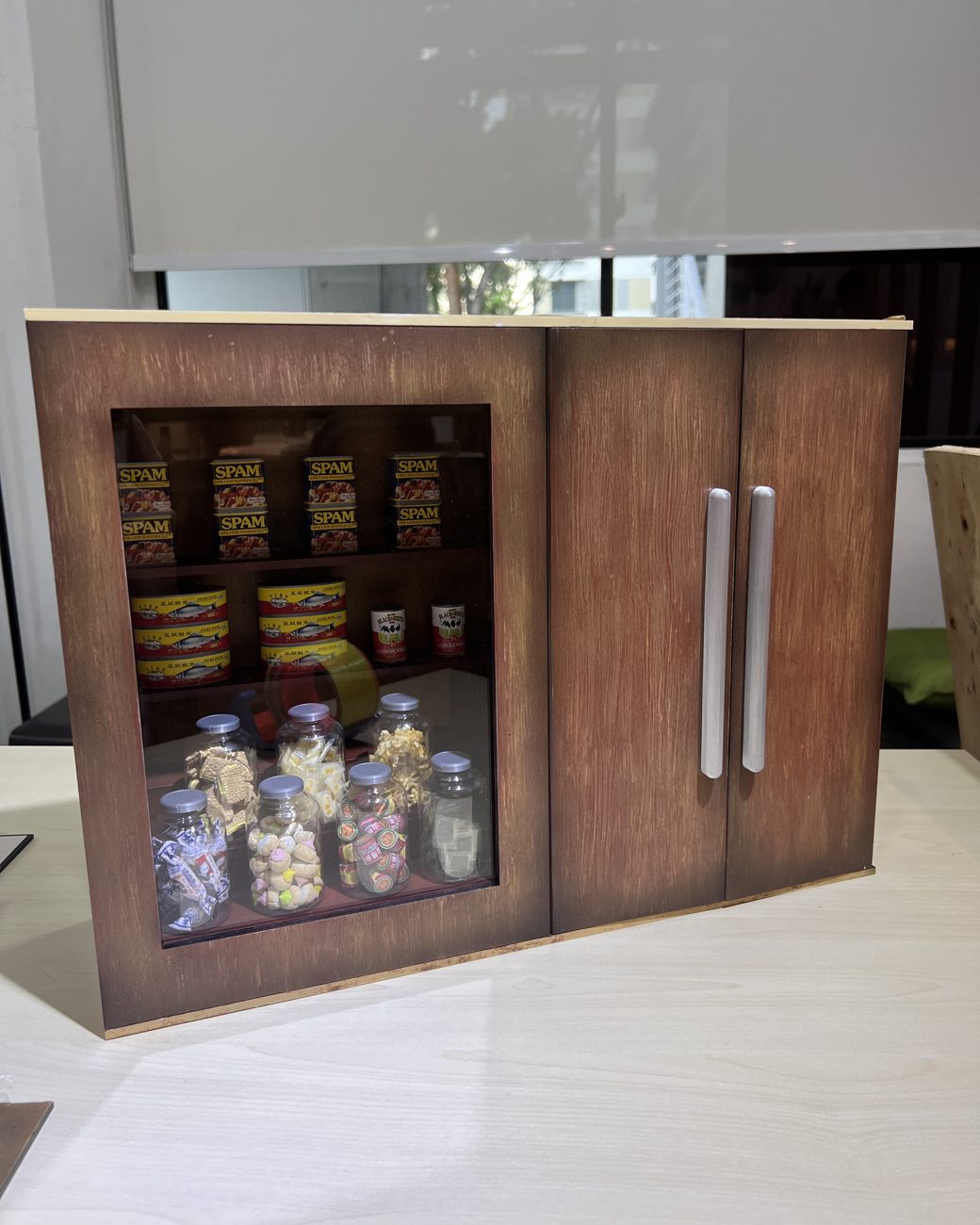 Detailed miniature provision-shop cabinet stocked with tiny replica groceries, hand-built for Shangri-La Hong Kong